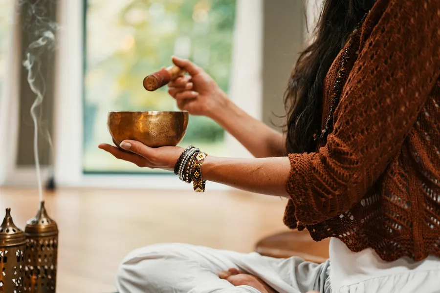 Klangschale wird in ruhiger Meditation angeschlagen